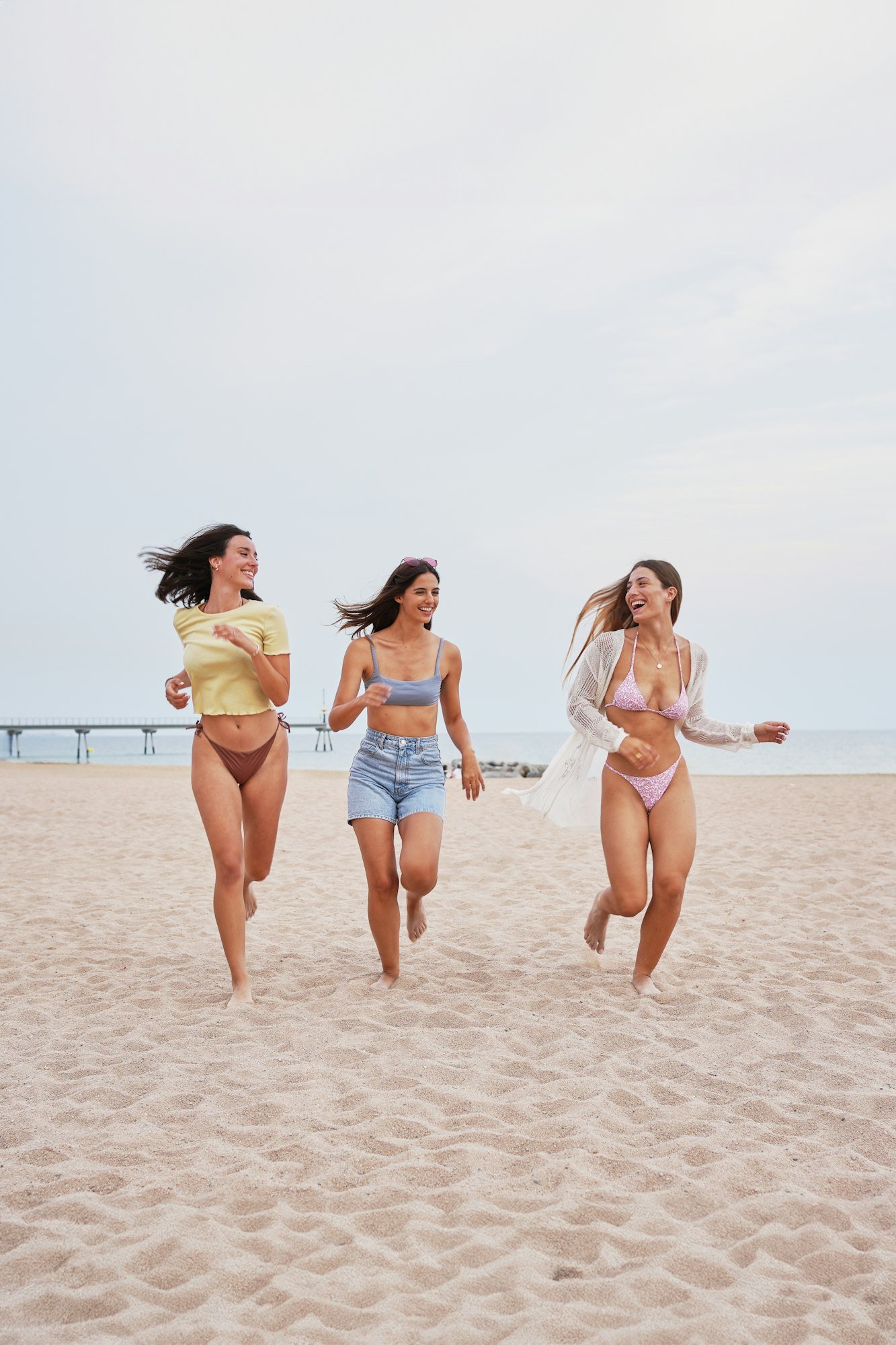 Group of friends cheerful running excited along beach. Caucasian healthy women